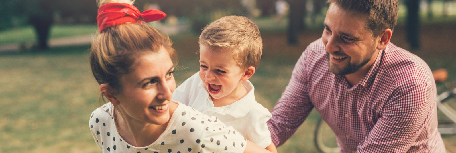 Familie spielt lachend beim Picknick